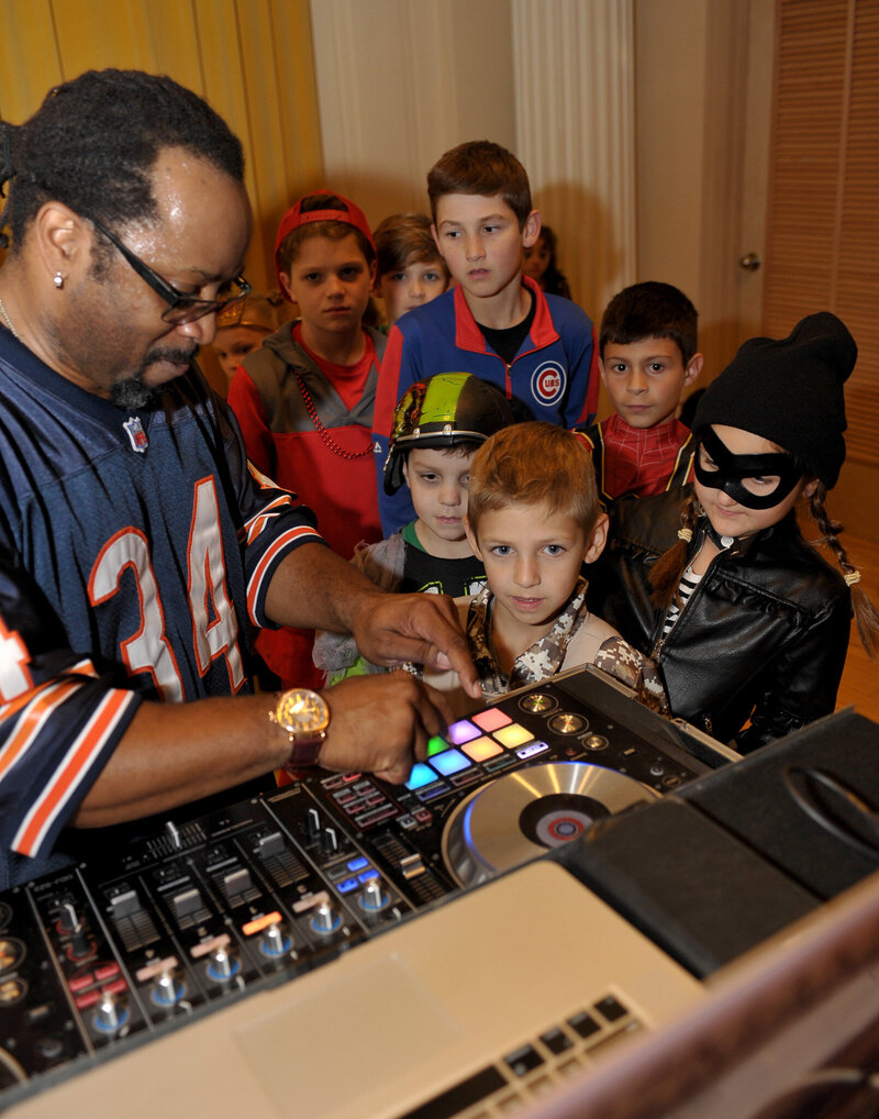 DJ teaching kids with costumes at DJ booth