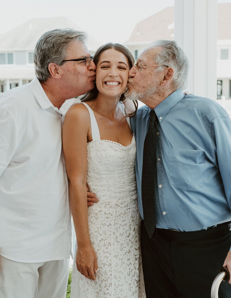 Father and grandfather kissing bride on cheeks at Temecula wedding