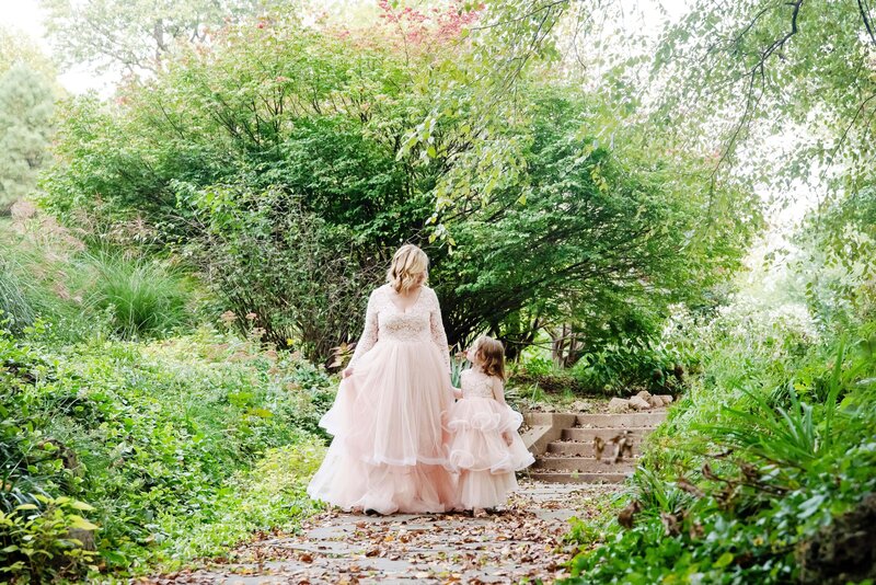 st-louis-motherhood-photographer-mom-and-daughter-in-pink-gowns-waliking-on-path-at-lafayette-park-in-st-louis