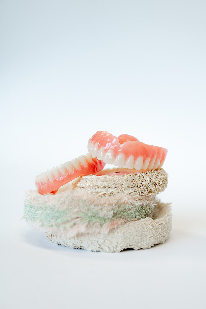 A set of dentures created by KDS sits  atop three wheel brushes used in the creation of custom dentures.