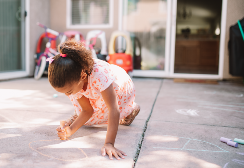 Toddler playing outside with chalk at the daycare Books & Blankets in Elk Grove, CA.