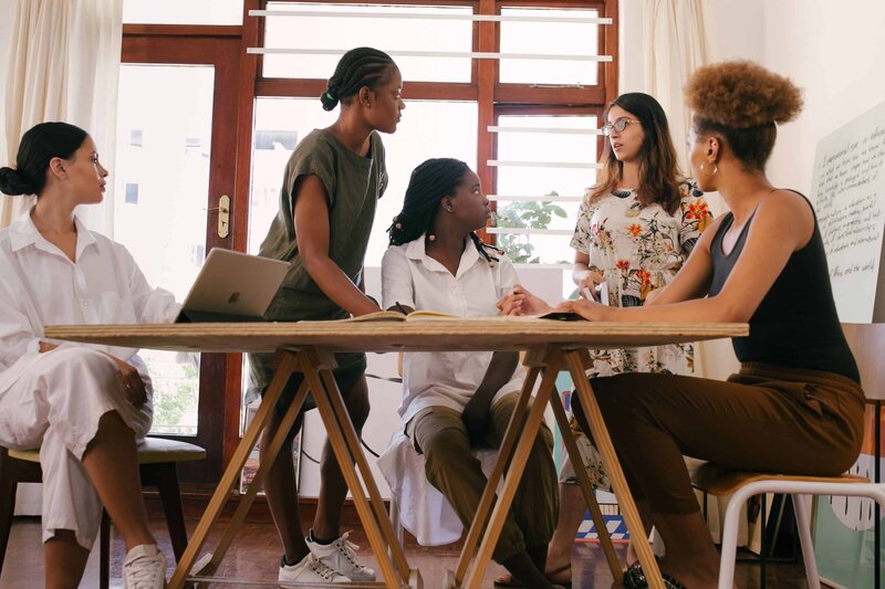 a group of women having a meeting at a table