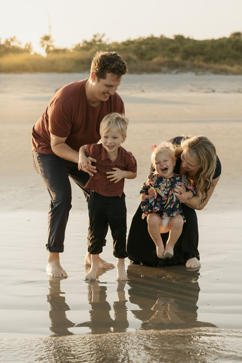 Family of 4 with toddlers, playing on the beach during a family photo session with Orlando photographer Melissa Vinsik