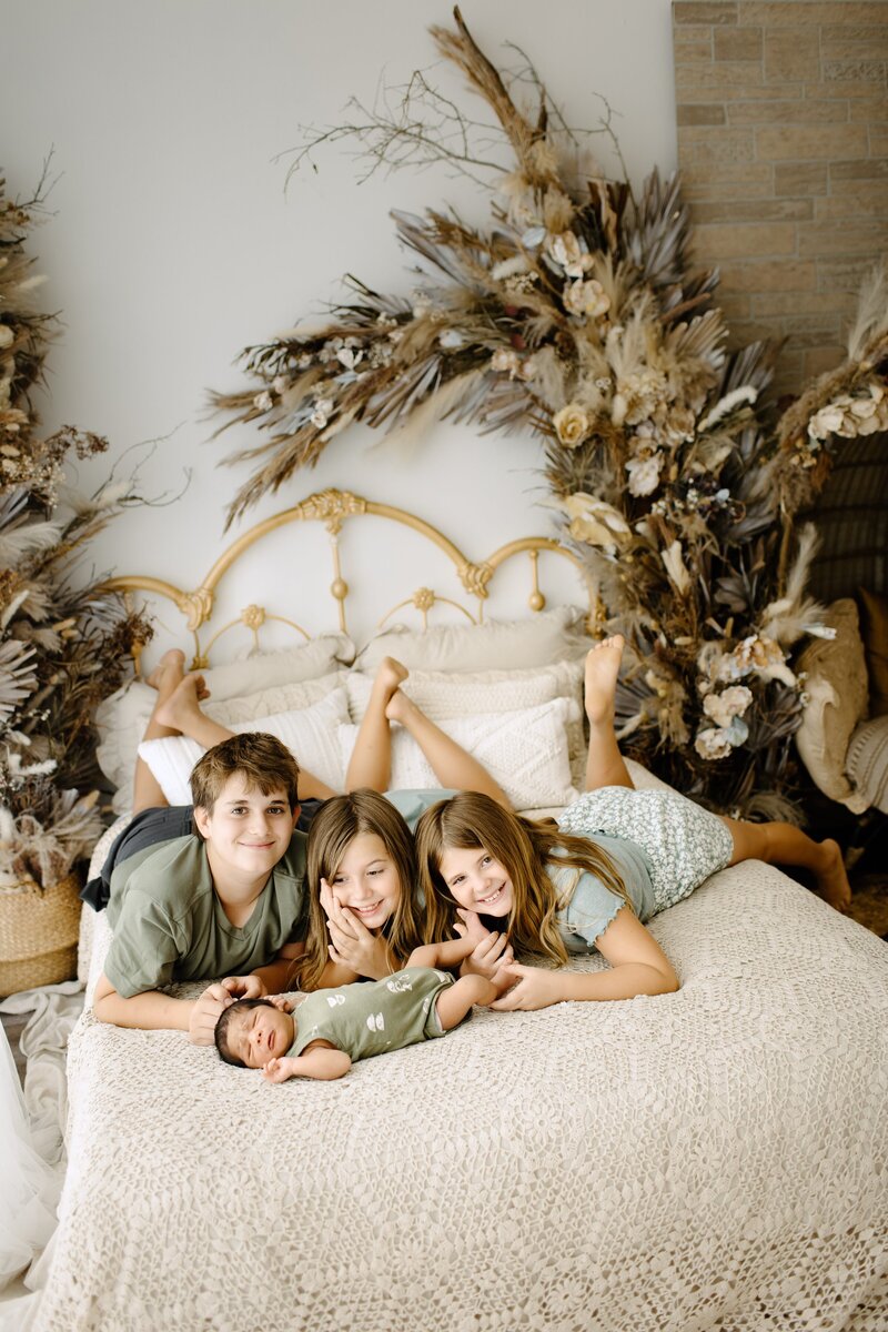 Newborn photography family picture kids laying in bed with boho background in Tampa Bay, Florida Nadine B Photography