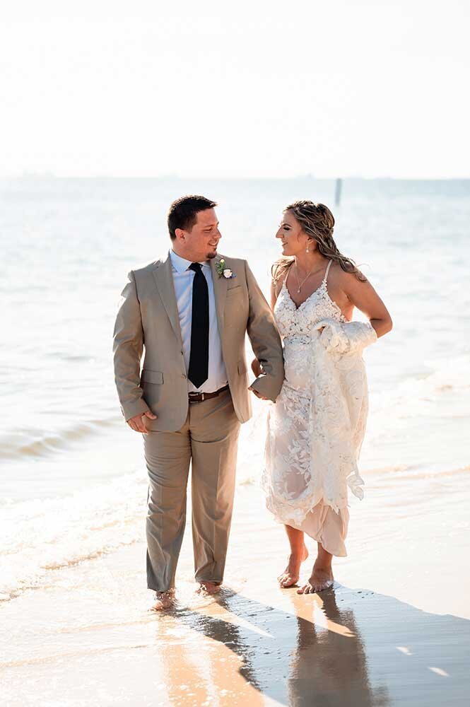bride and groom walking along St augustine beach - emmiclaire jacksonville wedding photographer