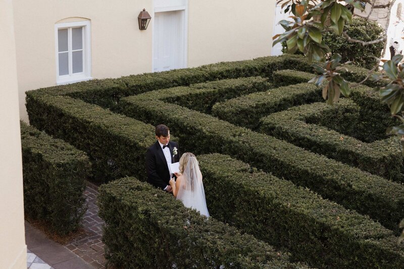 bride and groom stand together in maze of hedges in Charlotte