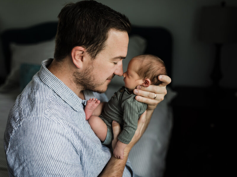 dad holding newborn baby boy nose to nose for in home session