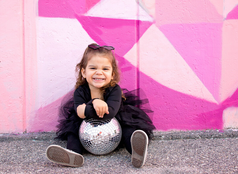 Little girl in black outfit in front of Riversides Pink Wall