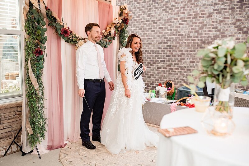 Bride and Groom together using photobooth during their outdoor backyard wedding reception