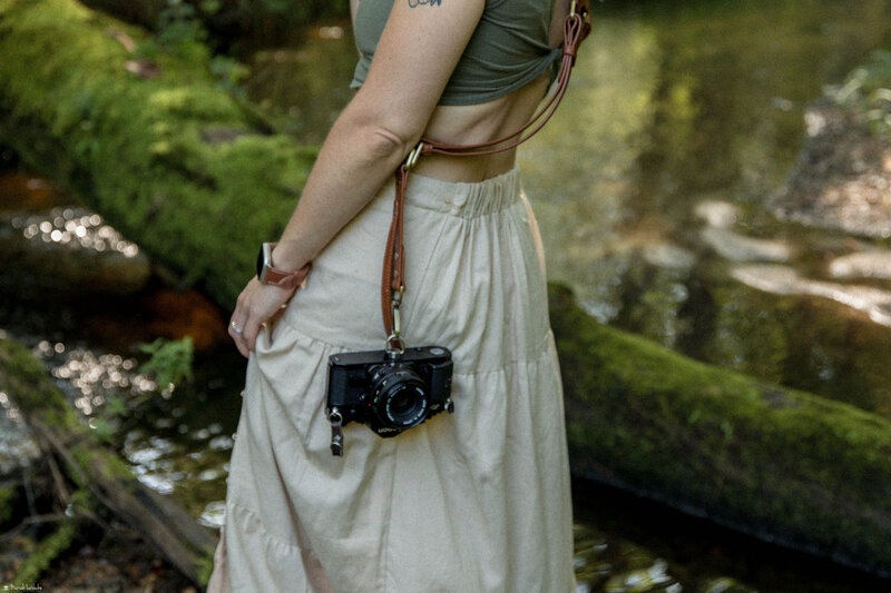 tattooed woman holding canon film cameras