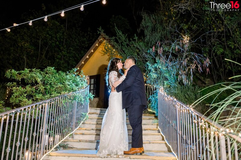 Bride and Groom stop on the stairs while holding hands and looking at one another