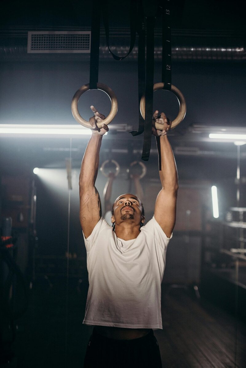 Personal trainer doing pull-ups on rings