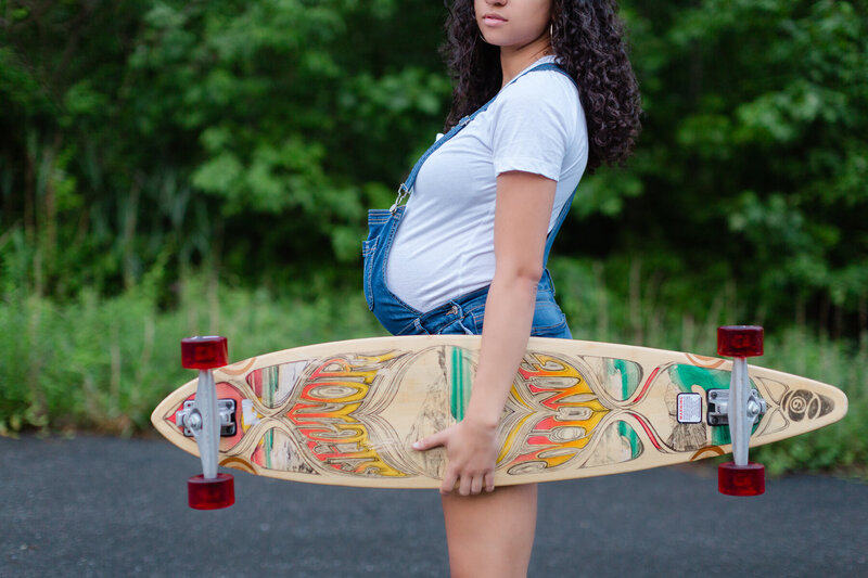 Hip new mom pregnant holding her longboard