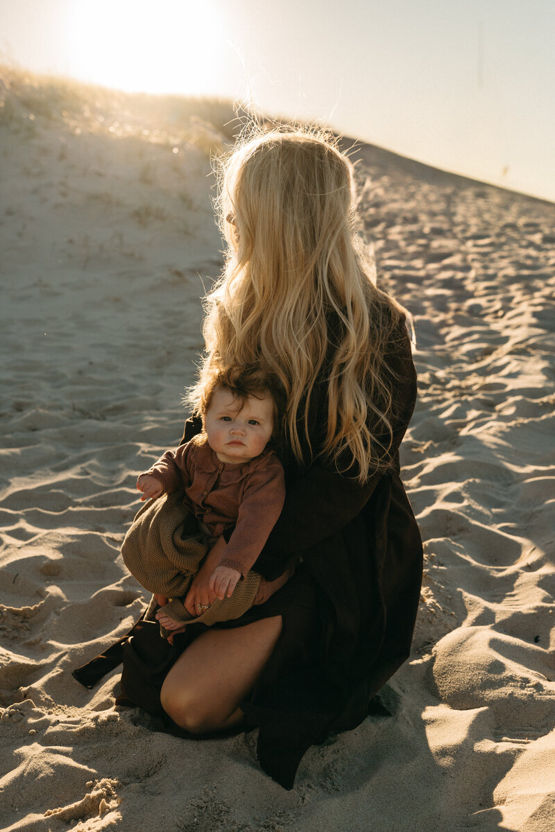 motherhood photography of mom hugging her children while sitting on a blanket at the beach in Lebanon, New Jersey