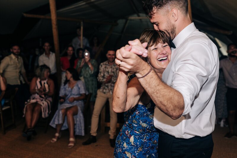 candid photo of mother and groom son dancing at his wedding in an element tipi at their christchurch wedding