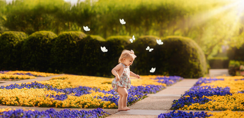 Toddler runs in a garden during Milestone Baby Portraits in Charleston, SC.