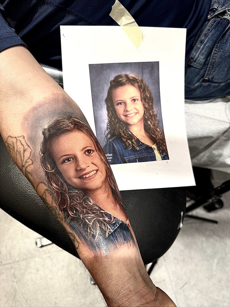 A beautiful and detailed portrait tattoo of a daughter, capturing her likeness with realistic shading and fine line work.