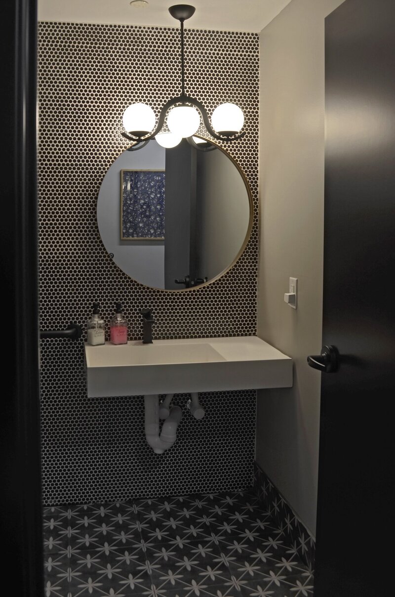 Large white sink under a round mirror