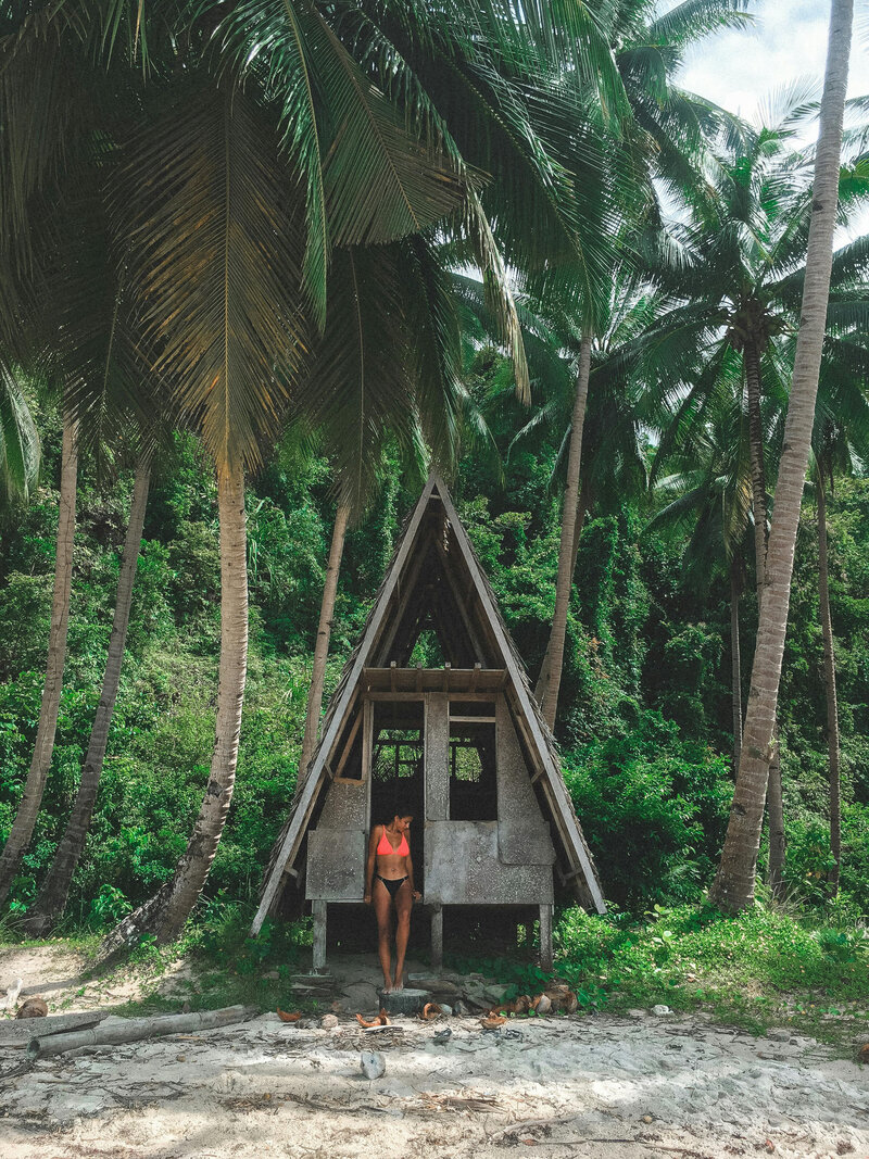 Woman standing in front of a beach hut