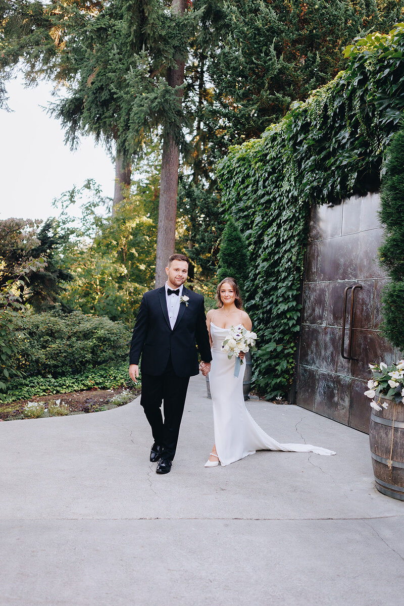 Bride and groom walking hand-in-hand at JM Cellars in Woodinville, Washington, after their wedding planned by Seattle wedding planner Wander Event Co., featured alongside client testimonials.