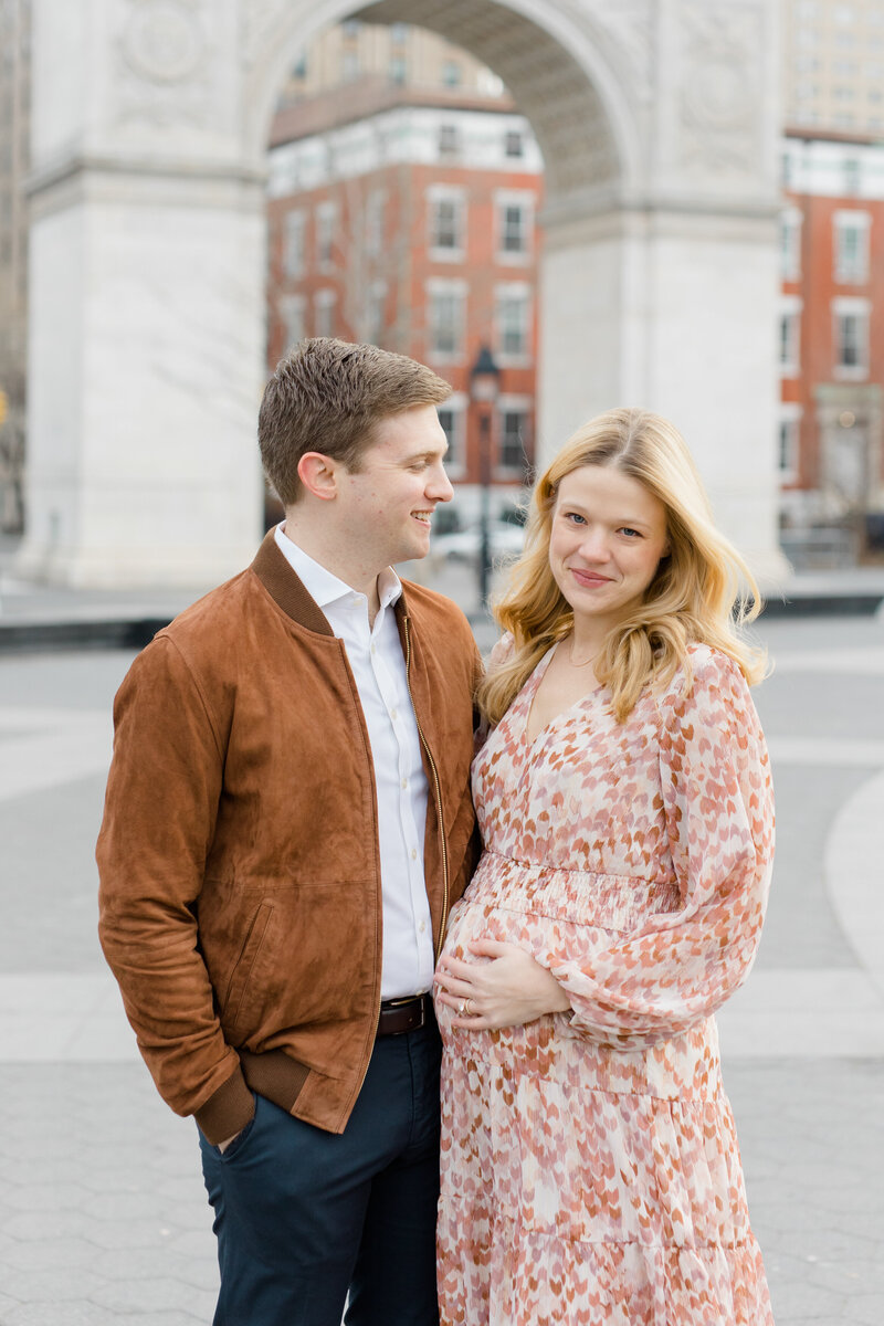 Couple looking at camera in NYC at maternity photography session