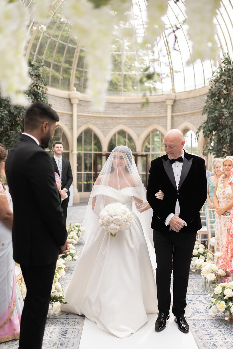 The emotional bride walks towards the groom during thier wedding ceremony at Cotswold wedding venue, Tortworth Court