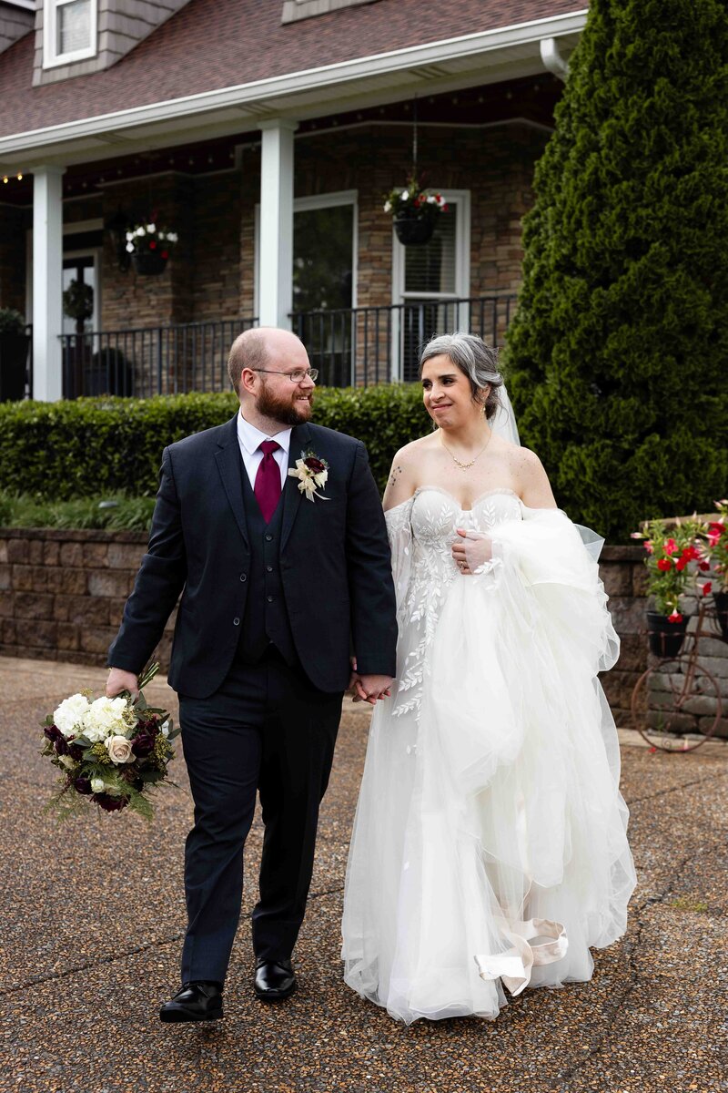 bride and groom walking and smiling at each other 