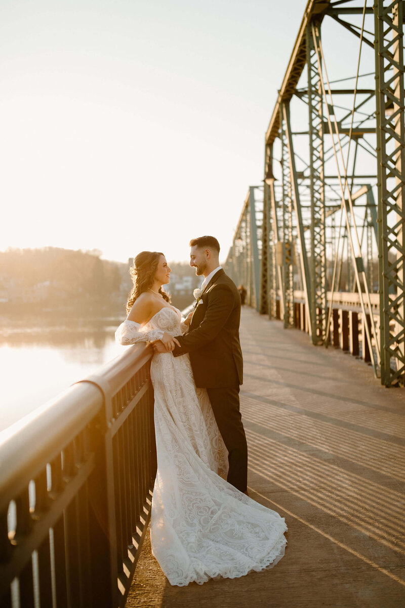 Bride (whimsical dress) and Groom (green suit) on bridge in New Hope, PA at sunset