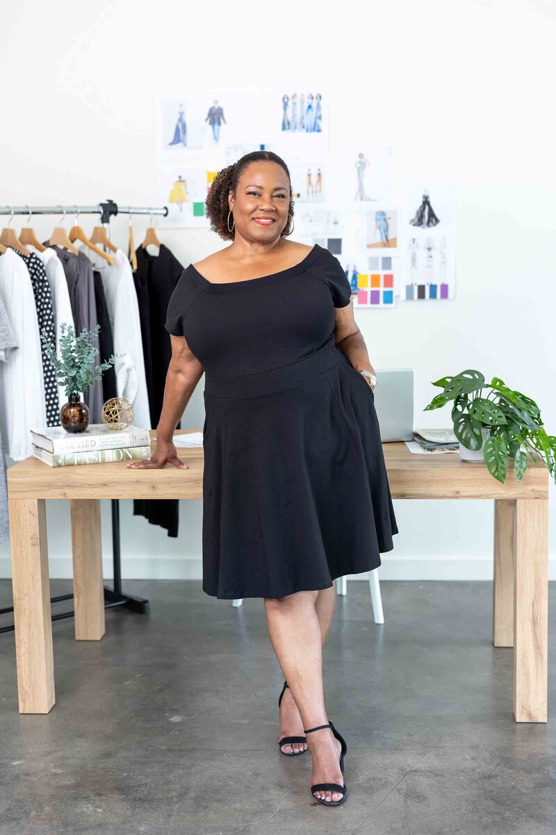 Content creation photography of a confident investor strategist in a sleek black dress, captured for a professional branding gallery.