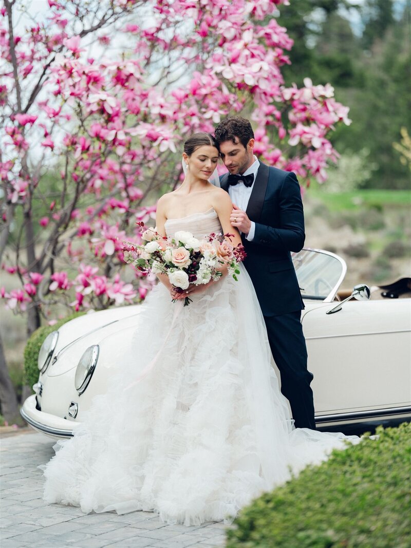 a couple having a romantic moment during their micro wedding in osoyoos- photographed by Yinet Gomez. the bride is wearing a white wedding dress, the groom a gray suit with a white shirt