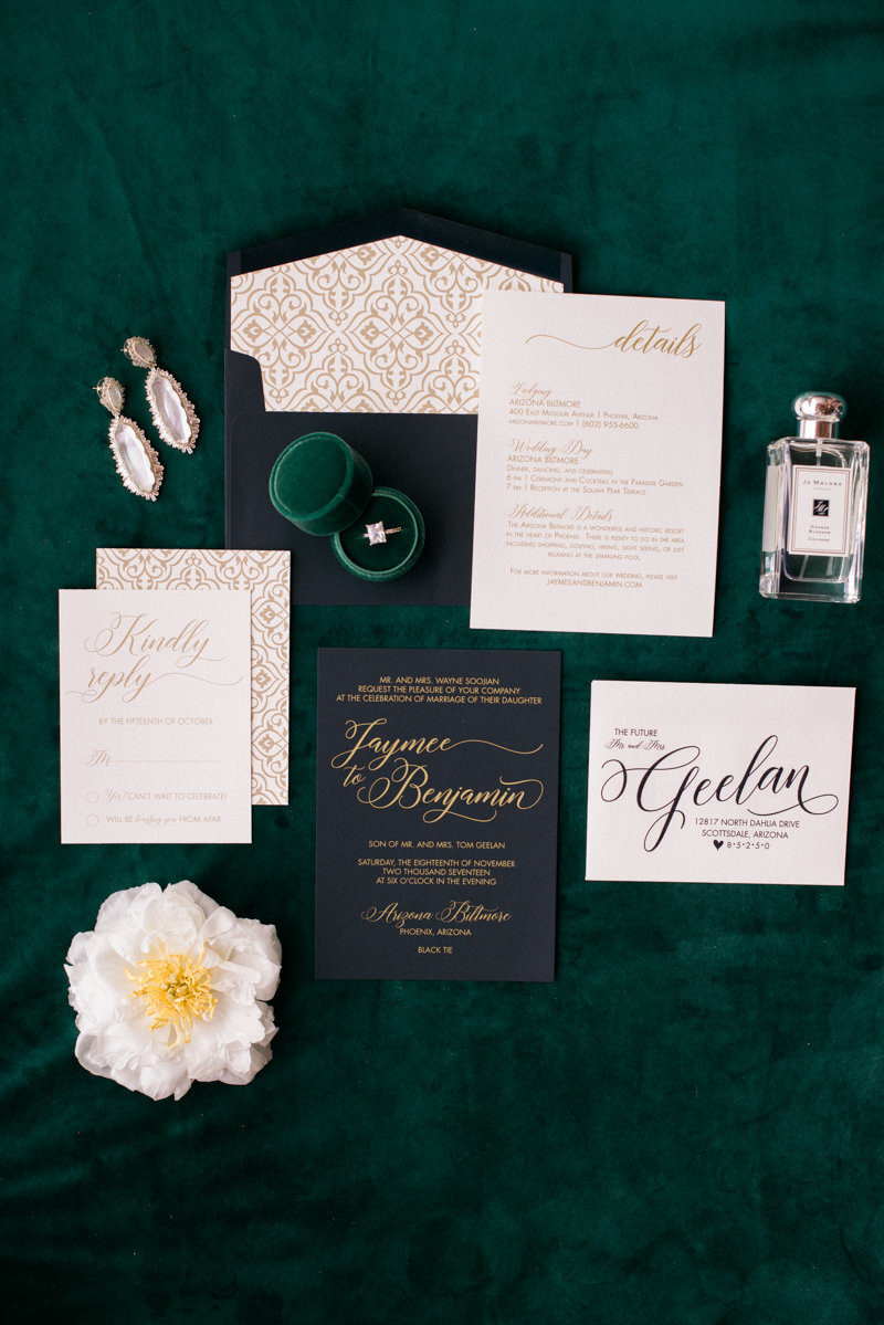 green and black wedding flatlay with invitation suite