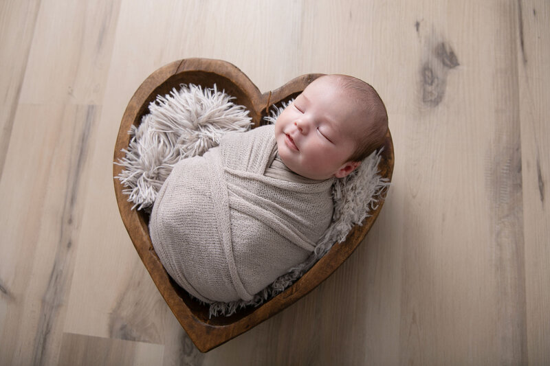 Neutral newborn in wooden heart bowl