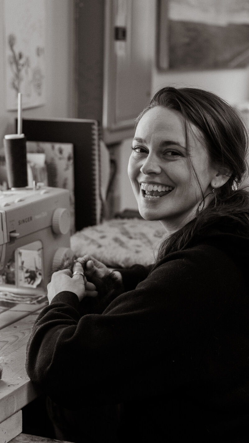 black and white image Natalie sitting at sewing machine