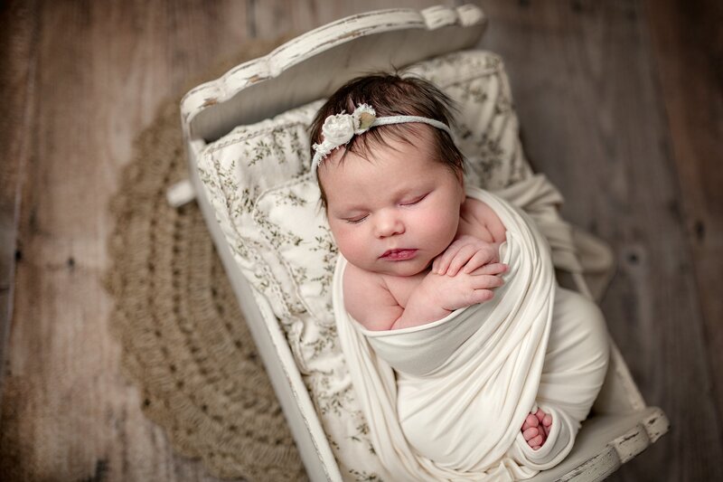 swaddled-newborn-girl-in-crib