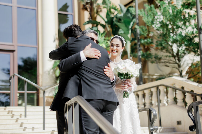 groom hugging father in law at a wedding at the four seasons Orlando by Florida wedding photographer.