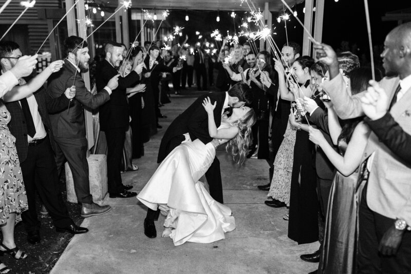 bride and groom dip kiss under sparklers