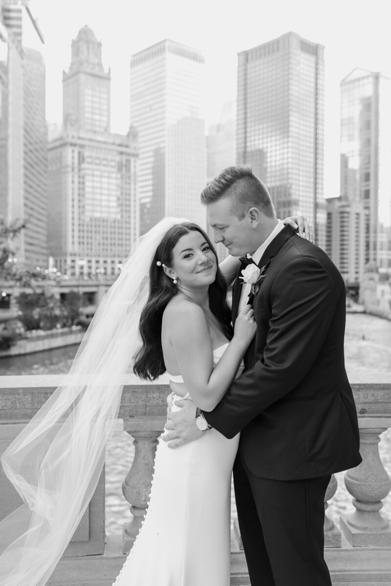 Bride and groom embrace with Chicago skyline behind them