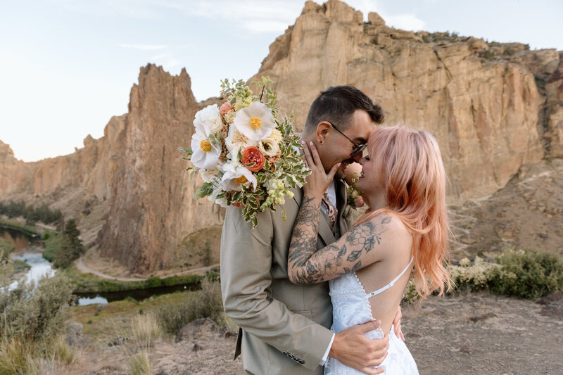 Bride and groom embracing at Smith Rock State Park in Oregon.