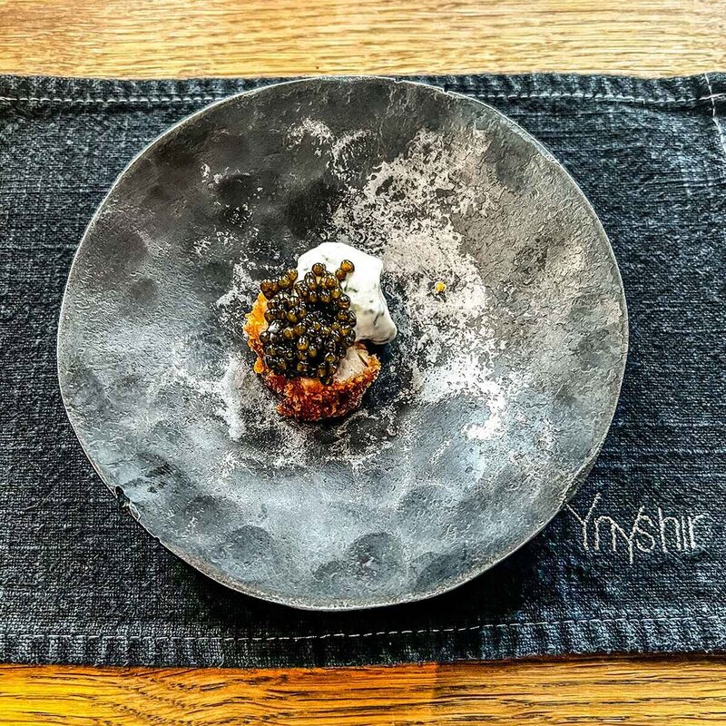 Stylish plate of veal and caviar on a stone coloured plate, on a denim table cloth