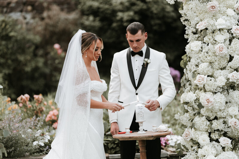 Serene Catholic wedding candle lighting ceremony, symbolizing unity and faith. Bride and groom gracefully ignite the unity candle, a timeless christian wedding tradition. Unity Candle