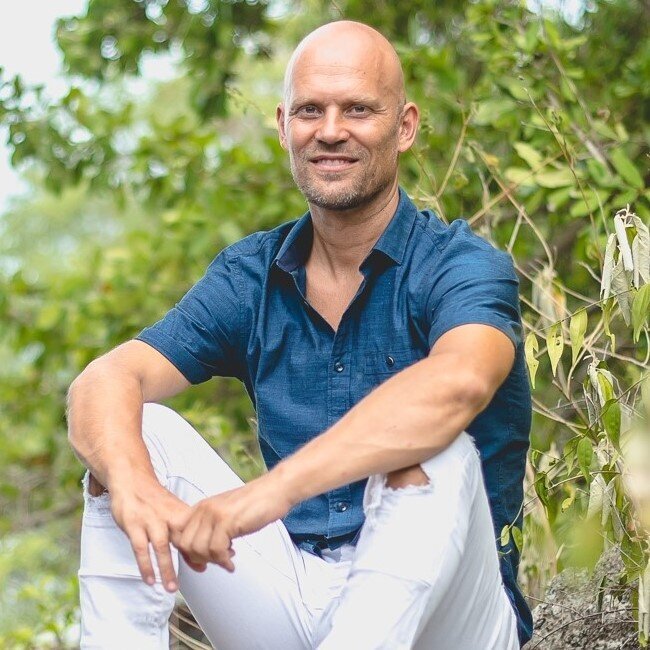 Man sitting in nature, looking at camera