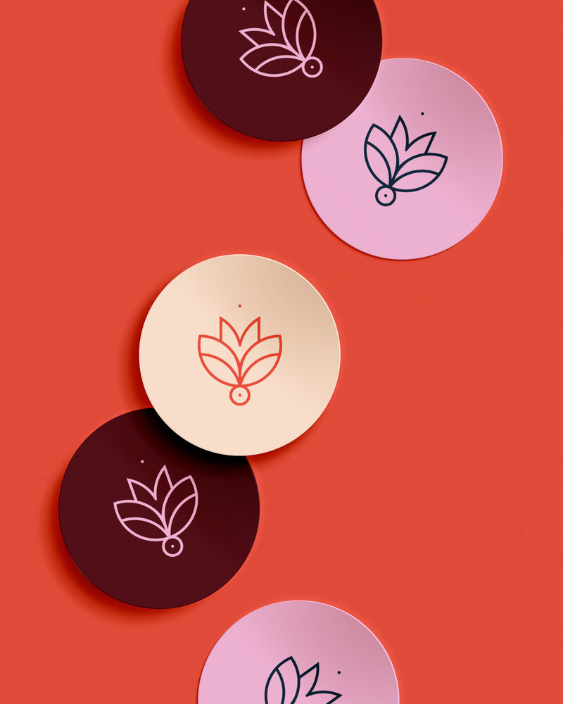 Ronde stickers met MEHR logo in verschillende kleuren op een rode achtergrond