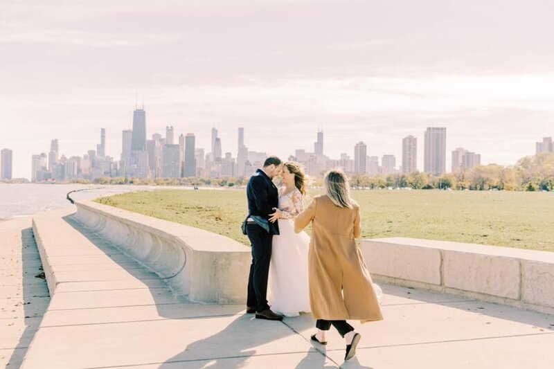 A candid behind-the-scenes photo of Chicago wedding photographer Ashley guiding a couple on their wedding day, capturing authentic and timeless moments.