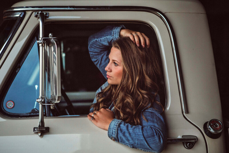 girl looking in mirror of vintage Ford truck