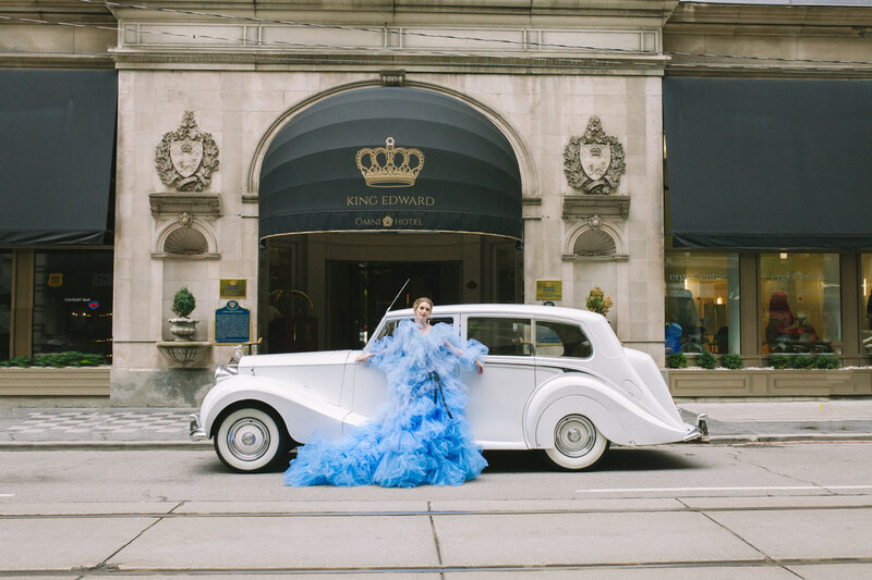 bride in front of a vintage rolls royce wearing a blue millian london gown