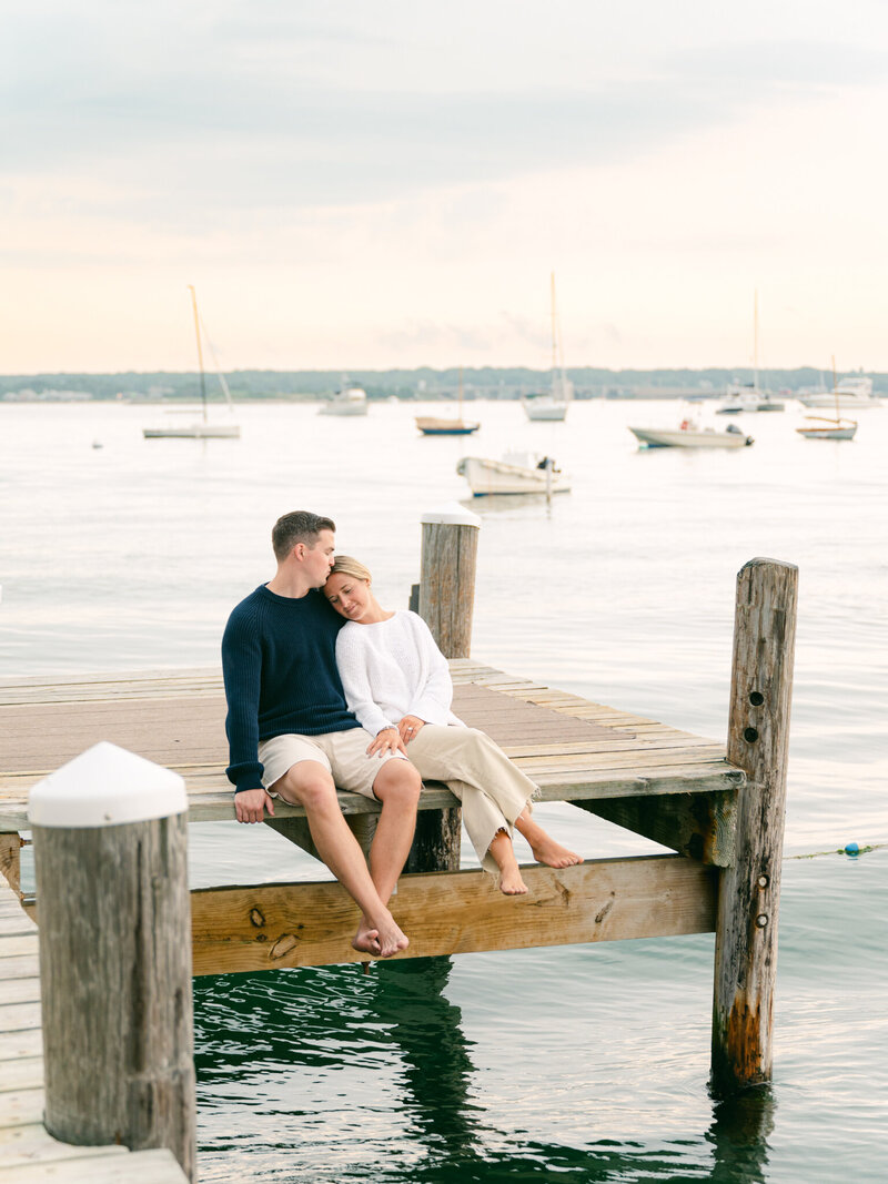 Stylish couple snuggle on the yatch club dock during their Martha's Vineyard Engagement Session.