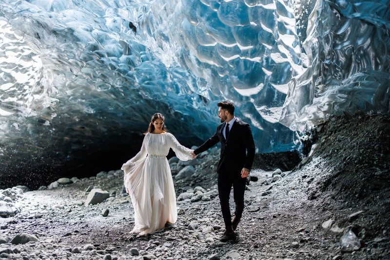 A couple walks through an ice cave in Southern Iceland at their destination elopement.