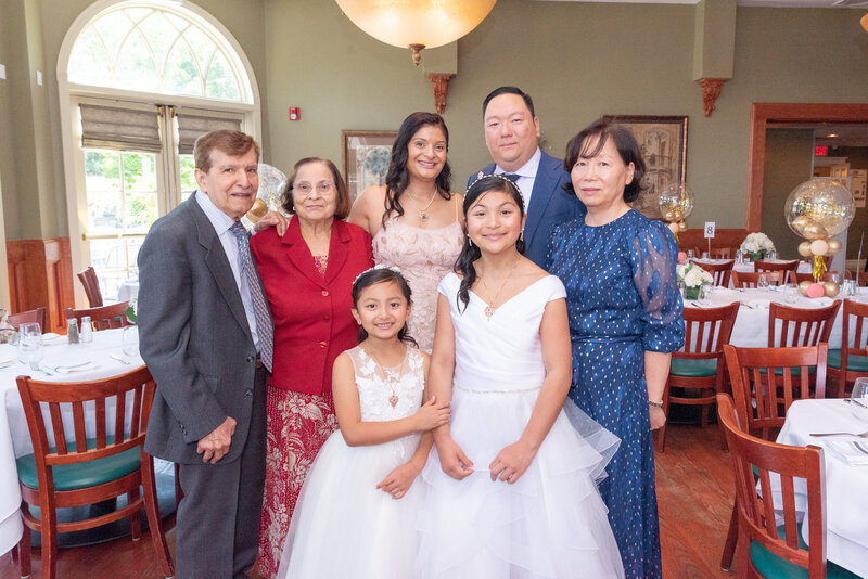 A family posing for photo at a birthday party event.