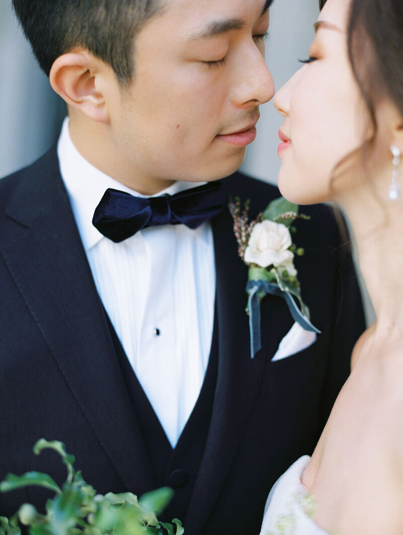 groom in tuxedo kissing bride