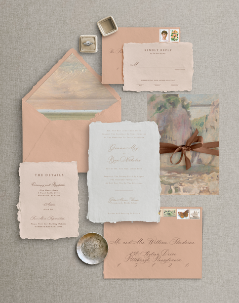 Flat lay of the Salt Air semi custom wedding invitation suite with envelopes, handmade paper, ribbon, and vellum wrap